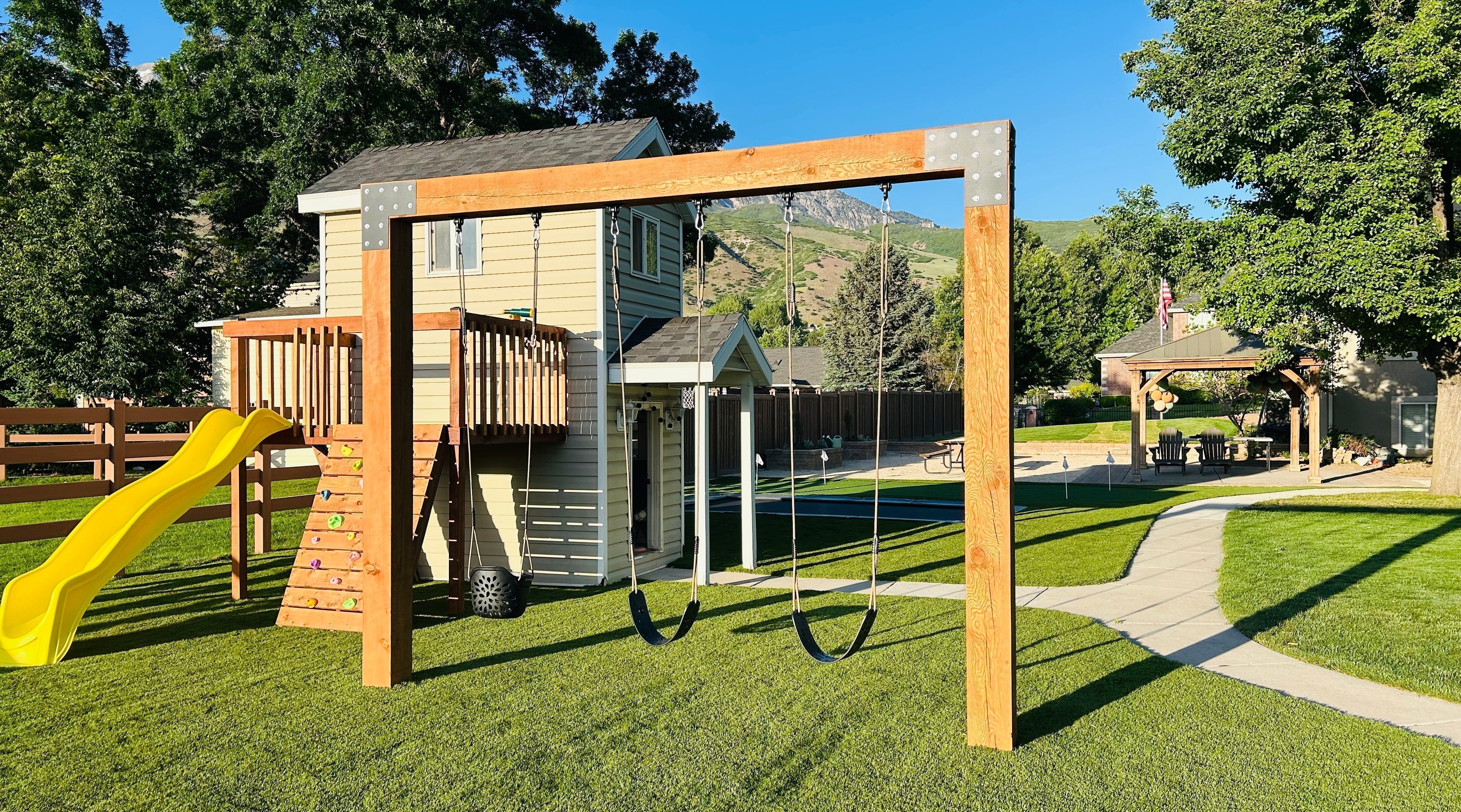 Wooden inground swing set in a family backyard, securely anchored — Saltair Swing Company
